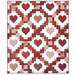 A patchwork quilt featuring a repeating pattern of hearts in shades of red and pink isolated on a white background. 