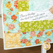 A colorful quilt featuring floral patterns and a white panel with a Psalm quote.