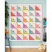 Colorful quilt with geometric patterns and hearts, displayed against a light blue wall.