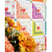 Colorful quilt featuring patchwork hearts, with vibrant floral patterns and a bouquet in the foreground.