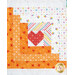 Close-up of quilt block with a heart shape in the center, surrounded by patterned borders in orange and white.