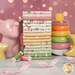 A stack of colorful fat quarters from the Baby Girl collection, staged with a pink elephant figurine, and a colorful stacking toy.