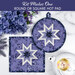 Two completed versions of the blue Folded Star Hot Pads, staged on a white marble countertop with coordinating decor like flowers and a porcelain tea pot.