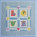 Quilt featuring the letters L, O, V, E in colorful patches, with teddy bear motifs and hearts.