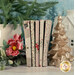 A stack of the fabrics included in the Merry Little Christmas - Cream 5 fat quarter set, with pine trees and a vase and flowers and a house and a Christmas tree candle