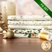 A stack of the fabrics included in the FQ Set Cream/Gold by Stof Fabrics, with candles, ornaments, and thread.
