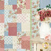 A shot of the right side of the quilt, with a white vase full of roses displayed on a cream dresser peeking into the right side of the frame. 