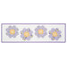 The completed Bloomberg table runner colored in white, yellow, and purple floral fabrics, isolated on a white background.