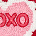 Close up of embroidery design featuring a pink heart with xoxo in red, surrounded by fluffy white edges.