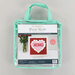 A clear, mint green carrying bag containing a valentine embroidery kit by KimberBell.