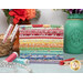A stack of the fabrics included in the Aunt Grace Goes Scrappy collection, with jars and flowers and clothespins and thread and measuring tape.