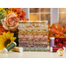 A stack of the fabrics included in the Evening On The Prairie collection, with flowers and leaves and thread.