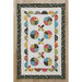 Colorful quilt with circular patterns and flowers, bordered by a floral trim on a light background.