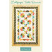 A colorful quilted table runner featuring circular patterns in various colors and a floral border.