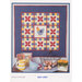 A colorful quilt with a chicken and flowers design, displayed with rustic decor and eggs.