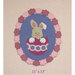 A plush bunny inside a decorative egg, framed by pink and purple scalloped detailing.