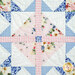 Close-up of a patchwork quilt block featuring floral and gingham patterns in soft pastel colors.