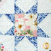 Up close of a patchwork quilt featuring a star-shaped design with blue and pink floral patterns, 