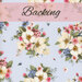 A floral fabric featuring white and pink flowers on a light blue background, labeled Backing.