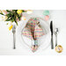 A top down shot of a place setting with the reversible gingham fabric of the napkin faced out.