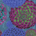 Colorful floral pattern featuring large dahlias in shades of blue, purple, and green on a teal background.