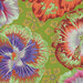 Brightly colored floral pattern featuring large hibiscus-like flowers on a green background.