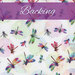 A swatch of white fabric with multicolor dragonflies and pointillism spheres. A warm purple banner at the top reads 