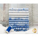 A stack of the winter fabrics included in the Ice collection, with snow and trees and snowflakes and thread.