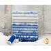 A stack of the winter fabrics included in the Ice collection, with snow and trees and snowflakes and thread.