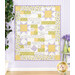 A patchwork quilt featuring floral patterns, star motifs, and handwritten text in soft yellow and lavender.