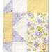 A colorful quilt featuring floral patterns in yellow, purple, and white fabrics