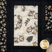 Close-up of quilt featuring playful tigers on a light background, surrounded by dark borders.