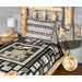 A rustic wooden bed features a black and cream animal-themed quilt, a matching pillow, and a patterned tote bag 