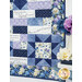 A colorful quilt featuring floral patterns and inspirational text panels in purple and blue tones.