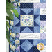 A patchwork quilt featuring blue floral patterns and a panel that reads 