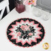 The completed Point of View Folded Star Table Topper colored in pink, black, and white fabrics from the Garden Picnic collection. The topper is staged on a white table with coordinating pink decor.
