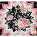 A top down view of the center of the topper, demonstrating details on the focus fabric, a black print with pink and white florals.