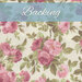 A swatch of cream fabric with blooming pink roses and sprawling leaves. A muted blue banner at the top reads 