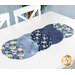 A table runner featuring a twisty design of blue colored fabrics with floral patterns.