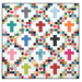 Colorful quilt featuring a pattern of crosses, hearts, and squares in various fabrics isolated on a white background