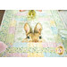 A patchwork table runner features a rabbit's face surrounded by soft pastel colors and floral patterns.