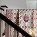 The completed Jane Austen Coverlet Kit, artfully draped over a bannister, showing off fabric details.