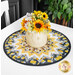 The table topper staged on a white table with a vase of yellow and white summer flowers displayed on top of the mat.