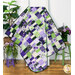 The completed Ten Square Scramble Quilt, colored in bright purple, cream, and green fabrics from the Georgina collection, artfully draped over a white quilt ladder and staged with coordinating greenery and decor.