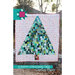 A patchwork quilt features a scrappy Christmas tree design in various greens on a white starry background.