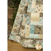 A close up shot of the quilt draped over a ladder, demonstrating fabric, piecing, border, and binding details while showing quilt movement.