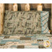 A shot of the Magic Pillowcase in brown and blue, staged on a bed with a matching patchwork quilt in a cabin setting.