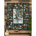 The completed Lone Wolf Stained Glass Panel Quilt, colored in rich green, brown, and blue hues with a watercolor wolf panel centerpiece, hung on a brown wood paneled wall with coordinating decor and greenery.