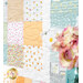 Close-up of a colorful quilt featuring various patterns with a bouquet of flowers in the foreground.