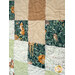 A close-up of a quilt featuring a patchwork design with foxes, deer, and floral patterns.